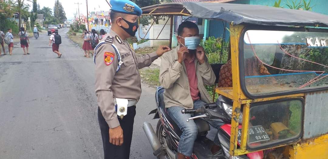 Kanit Provost Polsek Payung, AIPDA EP. Ginting membagikan masker kepada masyarakat yang tidak menggunakan masker.