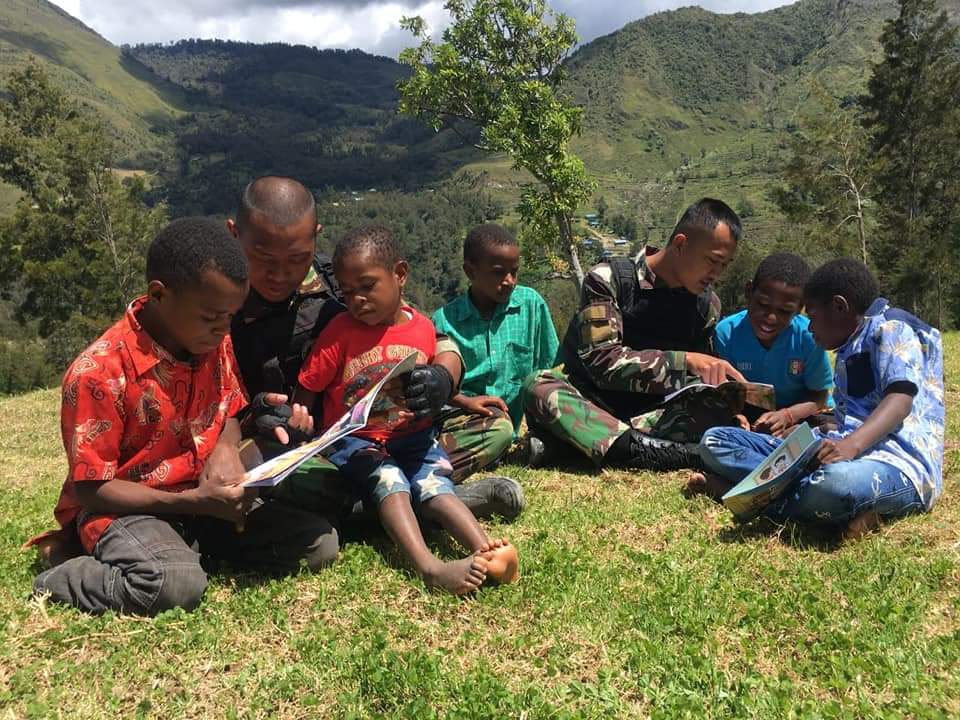 Personel Pos Pirime Satgas Yonif MR 412 Kostrad membawakan buku-buku bacaan dan buku bergambar, sebagai upaya membangkitkan semangat belajar anak-anak di Kampung Bugumbak Distrik Pirime Kabupaten Lanny Jaya, Papua.