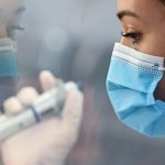 A laboratory technician uses a pipette device to process samples to t